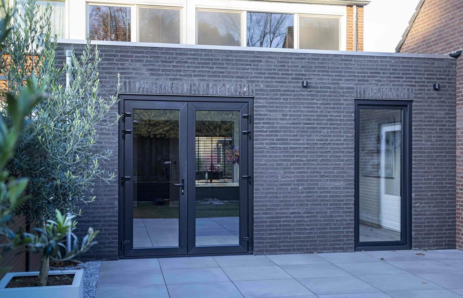 Aanbouw met zwarte pui en terras