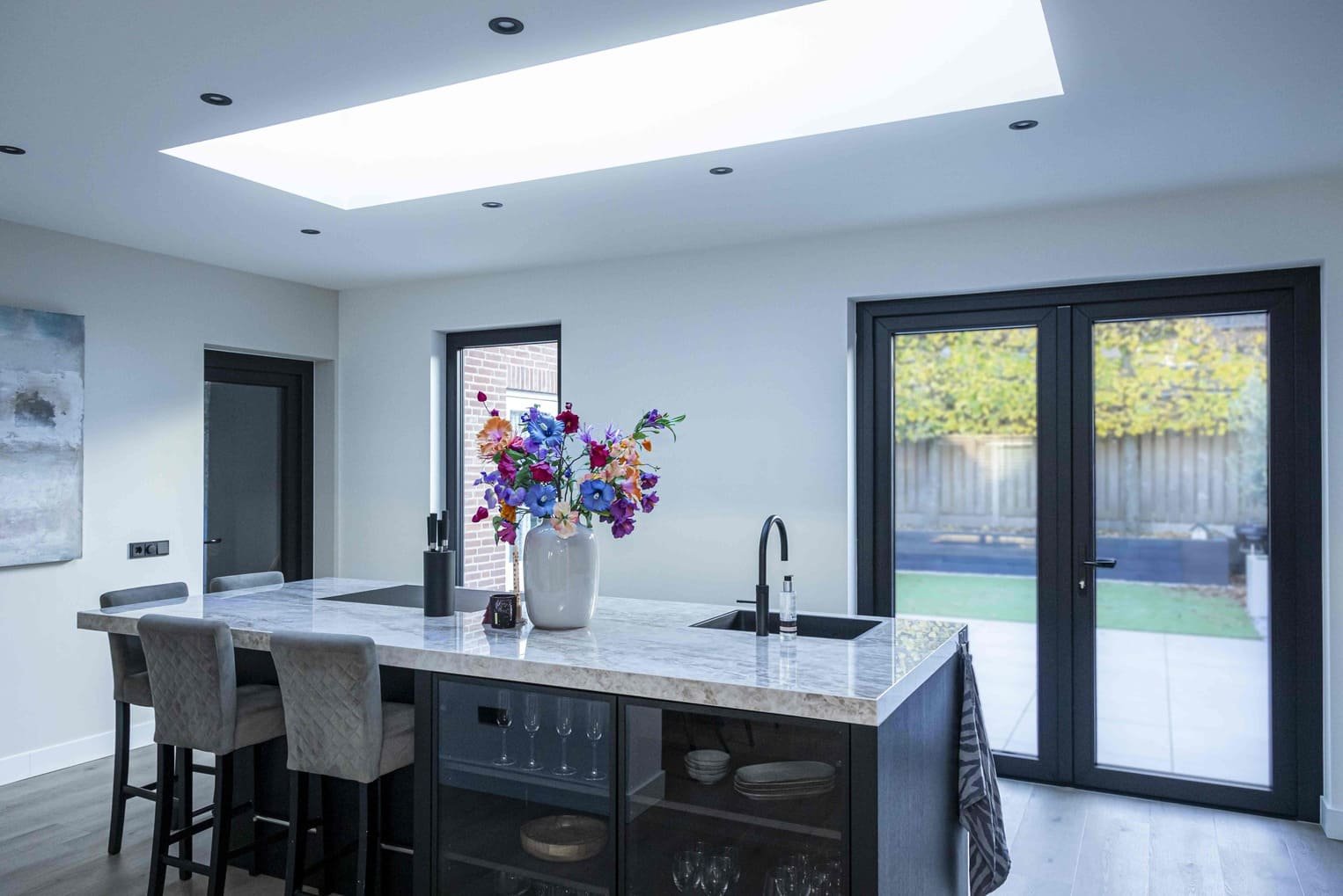Moderne keuken in een aanbouw met uitzicht op de tuin
