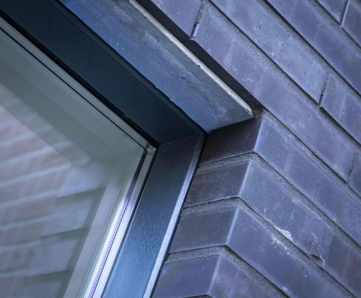Raam met metalen kozijn in bakstenen muur