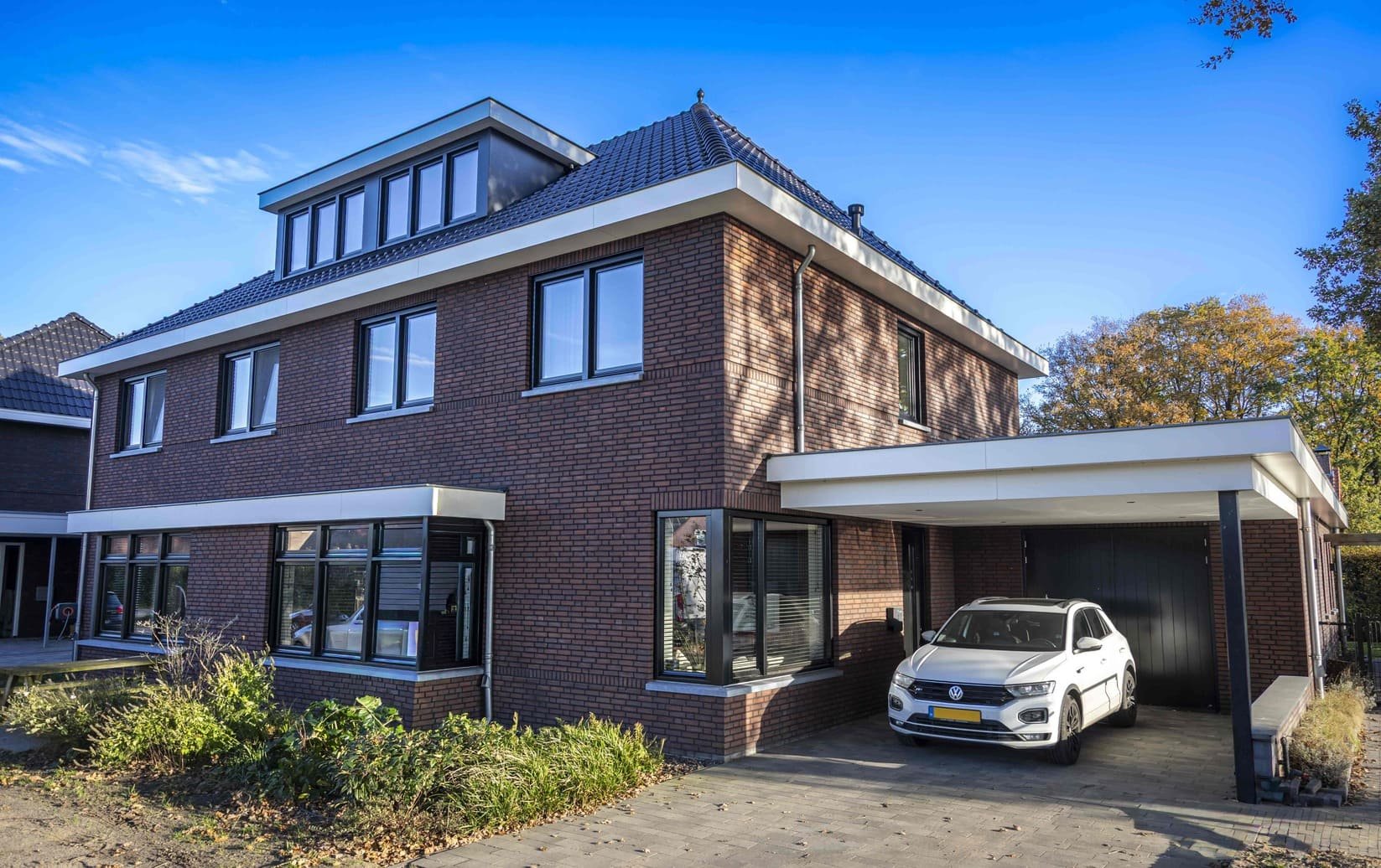 Moderne bakstenen nieuwbouwwoning met carport